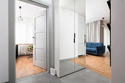 a glass door in a living room with a blue couch at City of the Kings - Riverside B22 in Kraków