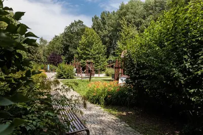 a garden with a fence and trees and flowers at City of the Kings - Riverside B22 in Kraków