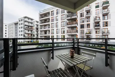 a balcony with a table and chairs and a building at City of the Kings - Riverside B22 in Kraków