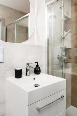 a bathroom with a white sink and a shower at City of the Kings - Riverside B22 in Kraków