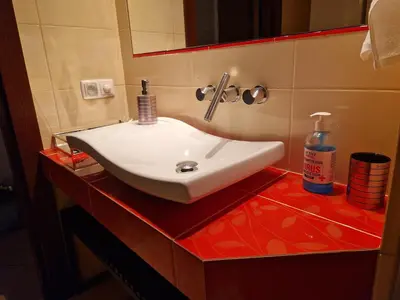 a white sink on a red counter in a bathroom at Słoneczna Skarpa in Rabka-Zdroj
