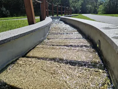 a concrete retaining wall with water running down a sidewalk at Słoneczna Skarpa in Rabka-Zdroj