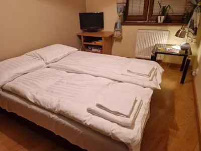 a bed with white sheets on it in a room at Słoneczna Skarpa in Rabka-Zdroj