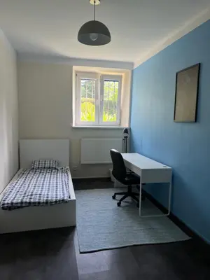 a bedroom with a bed and a desk and a window at Kasprowicza Rooms in Kraków
