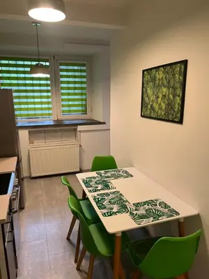 a kitchen with a table and green chairs at Kasprowicza Rooms in Kraków