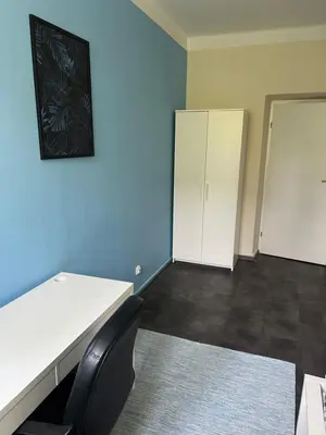 an empty room with a white desk and a cabinet at Kasprowicza Rooms in Kraków