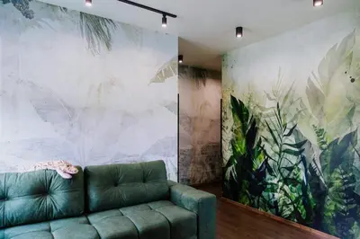 a living room with a green couch and a large painting at Jungle Apartment chill&bed Zator in Zator