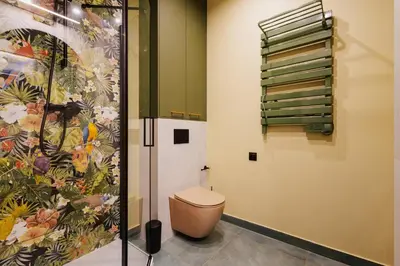 a bathroom with a toilet and a painting on the wall at Jungle Apartment chill&bed Zator in Zator