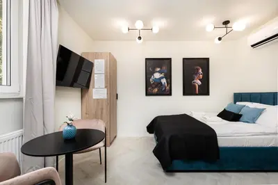 a bedroom with a bed and a table and a tv at Krowoderska 55 - by Upstairs in Kraków