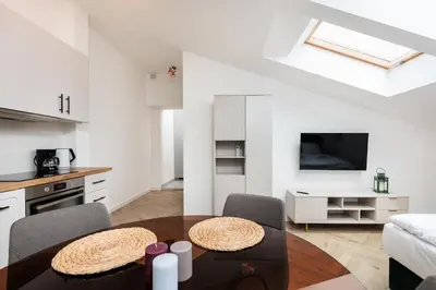 a kitchen and living room with a table and chairs at Krowoderska 55 - by Upstairs in Kraków