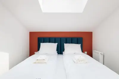 a bedroom with two beds with white sheets and a blue headboard at Krowoderska 55 - by Upstairs in Kraków