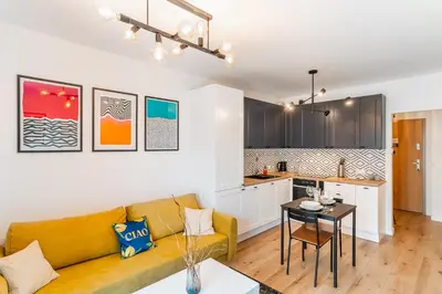 a living room with a couch and a table at Kraków Bagry Apt - Parking, Balcony, Workspace - by Rentujemy in Kraków