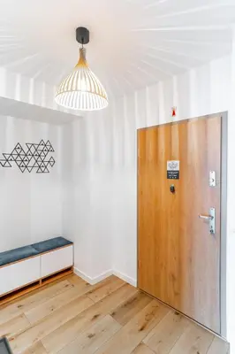 a room with a wooden door and a bench at Kraków Bagry Apt - Parking, Balcony, Workspace - by Rentujemy in Kraków