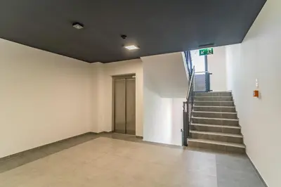 a hallway with a staircase and a stair case at Kraków Bagry Apt - Parking, Balcony, Workspace - by Rentujemy in Kraków