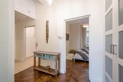 a hallway with a table and a room with a bed at Apartament Lubomirskiego Centrum Kraków in Kraków