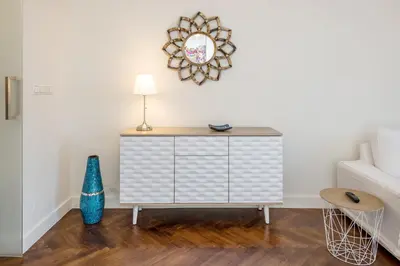 a living room with a dresser and a mirror at Apartament Lubomirskiego Centrum Kraków in Kraków