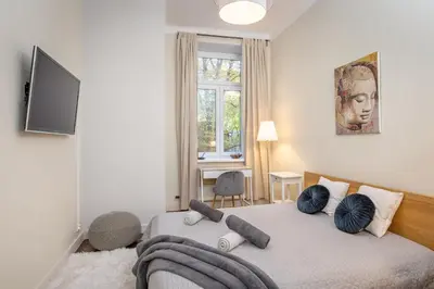 a bedroom with a bed with blue pillows on it at Apartament Lubomirskiego Centrum Kraków in Kraków