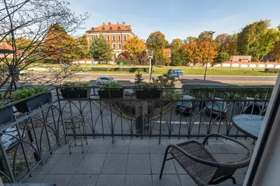 a balcony with chairs and a view of a building at Apartament Lubomirskiego Centrum Kraków in Kraków