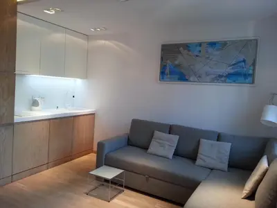 a living room with a couch and a kitchen at Modern Studio Apartments Old Town-Kazimierz in Kraków