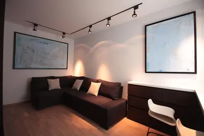 a living room with a brown couch and a white chair at Modern Studio Apartments Old Town-Kazimierz in Kraków