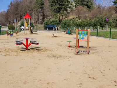 a playground with play equipment in the sand at Agroturystyka na Jurze Apartamenty z widokiem na Zamek Jacuzzi Sauna Beczka in Ogrodzieniec