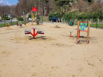 an empty playground with playground equipment in the sand at Agroturystyka na Jurze Apartamenty z widokiem na Zamek Jacuzzi Sauna Beczka in Ogrodzieniec