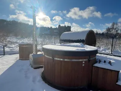 a snow covered area with a castle in the background at Agroturystyka na Jurze Apartamenty z widokiem na Zamek Jacuzzi Sauna Beczka in Ogrodzieniec