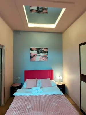 a bedroom with a large bed with a red headboard at Mirror Pink Studio Apartment in Kraków