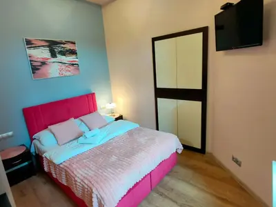 a bedroom with a bed with a red headboard and a mirror at Mirror Pink Studio Apartment in Kraków