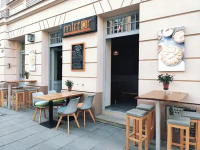 a restaurant with tables and chairs in front of it at Mirror Pink Studio Apartment in Kraków