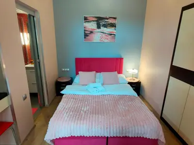 a bedroom with a large bed with a red headboard at Mirror Pink Studio Apartment in Kraków