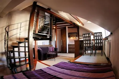 a living room with a spiral staircase in a house at Krakow Jacuzzi Apartment in Kraków