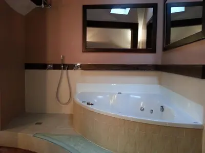 a bath tub in a bathroom with a mirror at Krakow Jacuzzi Apartment in Kraków