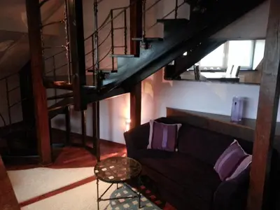 a living room with a couch and a staircase at Krakow Jacuzzi Apartment in Kraków