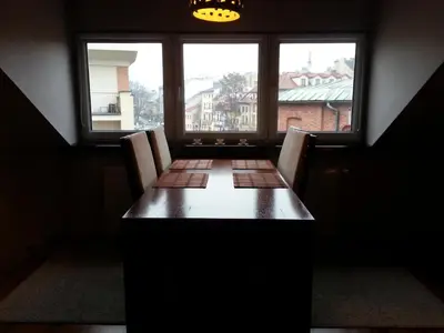 a table with chairs in a room with a window at Krakow Jacuzzi Apartment in Kraków