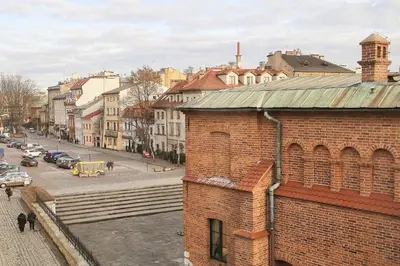a brick building in a city with a street at Krakow Jacuzzi Apartment in Kraków