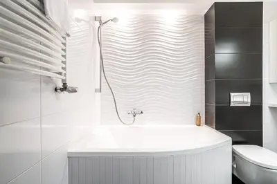 a white bathroom with a tub and a toilet at RentPlanet - Apartamenty Przemysłowa in Kraków