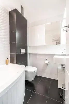 a white bathroom with a toilet and a sink at RentPlanet - Apartamenty Przemysłowa in Kraków