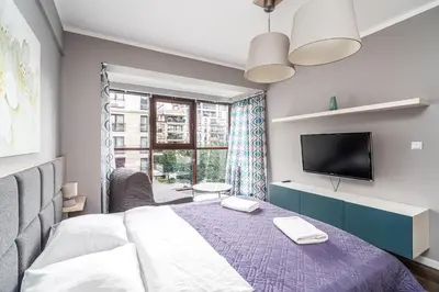 a bedroom with a bed and a tv and a window at RentPlanet - Apartamenty Przemysłowa in Kraków