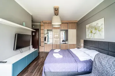 a bedroom with a bed and a flat screen tv at RentPlanet - Apartamenty Przemysłowa in Kraków