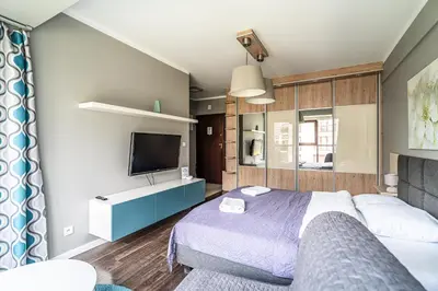 a bedroom with a bed and a flat screen tv at RentPlanet - Apartamenty Przemysłowa in Kraków