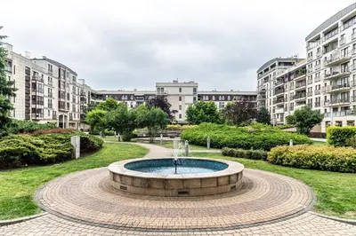 a fountain in the middle of a park with buildings at RentPlanet - Apartamenty Przemysłowa in Kraków