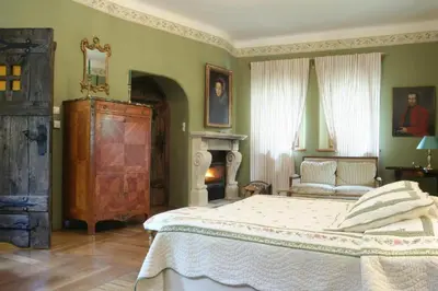 a bedroom with a large bed and a fireplace at Zamek Korzkiew in Korzkiew