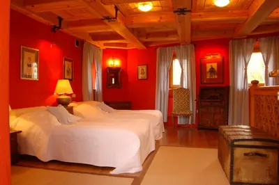 two beds in a bedroom with red walls at Zamek Korzkiew in Korzkiew