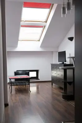 a living room with a skylight and a couch and a desk at Komfortowy apartament z klimatyzacją in Kraków
