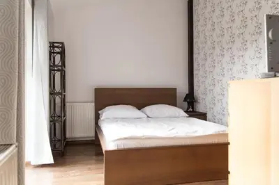 a bedroom with a bed with a wooden headboard at Przytulny apartament Kos w sercu Krakowa in Kraków