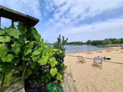 a beach with two chairs and people on the sand at Bagry Rooms2 - Apartament z sypialnią i miejscem postojowym in Kraków