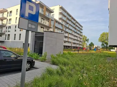a parking sign in front of a building at Bagry Rooms2 - Apartament z sypialnią i miejscem postojowym in Kraków