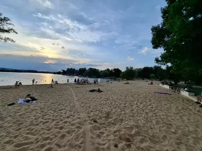 a group of people on the beach at sunset at Bagry Rooms2 - Apartament z sypialnią i miejscem postojowym in Kraków