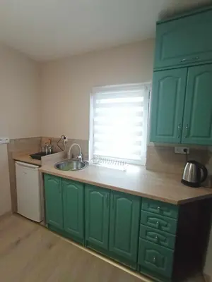 a kitchen with green cabinets and a sink and a window at Blisko Energylandii in Zator